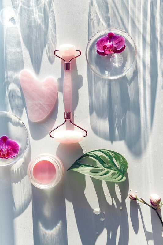 Skincare tool with scented candle and flowers